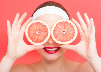 Woman holding grapefruit in front of her eyes
