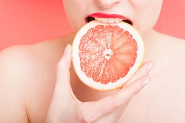 Female bite a slice of grapefruit