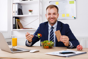 Man has healthy business lunch in modern office interior