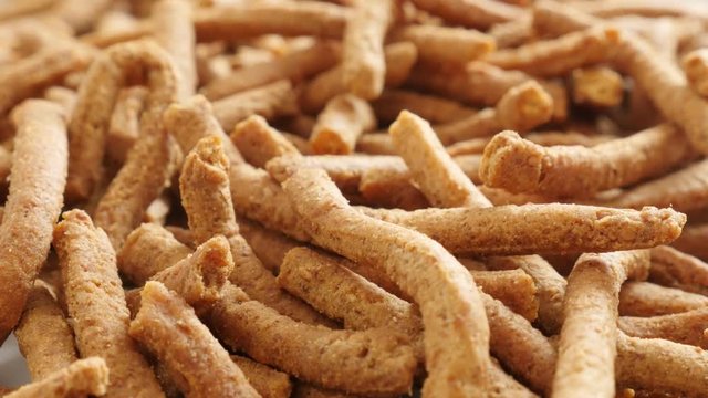 Tasty integral breadsticks fried in oil slow tilt 4K 2160p 30fps UltraHD footage - Close-up grissini snack made of dough with chilli 3840X2160 UHD tilting video