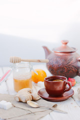Ginger tea with lemon, lime and honey on white.