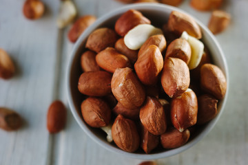 Dry peanuts in white bowl over the white table