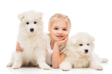 Little girl with a samoyed puppies