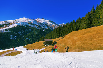 Perfect winter landscape in the Alps with green pine trees and clear blue sky and snowcapped...