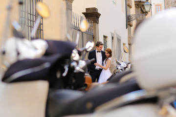 Groom and bride in the city near mopeds, selective focus