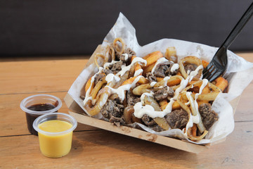 Poutine Curly fries with beef meat topped with cheese and mayo