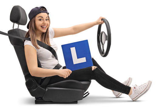 Happy girl holding an L-sign and pretending to drive