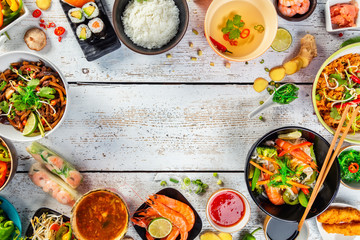 Asian food served on wooden table, top view, space for text