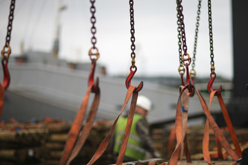 Fototapeta na wymiar Chains and hooks hoist with slings for loading timber in the port