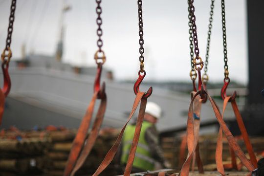 Chains and hooks hoist with slings for loading timber in the port