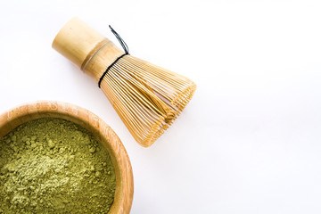 Matcha green tea in a bowl and bamboo whisk isolated on white background
