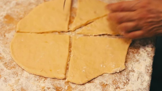 Woman cutting dough with a knife