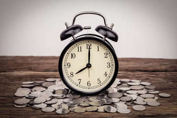 Fototapeta na wymiar Stack of coins with black alarm clock