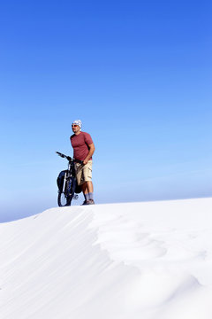 Traveling man on a bicycle in the desert.
