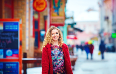 beautiful happy woman walking on crowded city street in winter