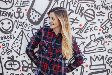 cheerfull teenager in a graffiti wall.