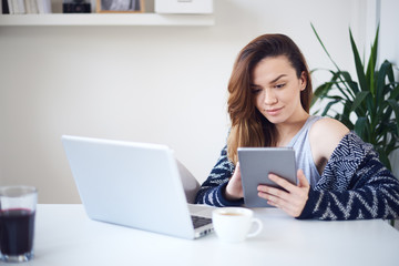 Fototapeta premium young woman reading using tablet at home