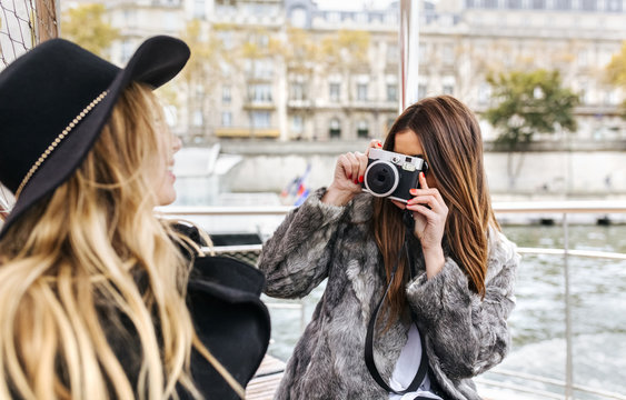 France, Paris, tourist taking picture of her friend with camera