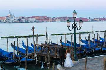 Fototapeta na wymiar Groom and bride in Venice Italy near gondola
