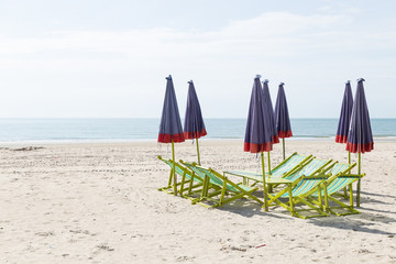 Beds and umbrellas on the beach.