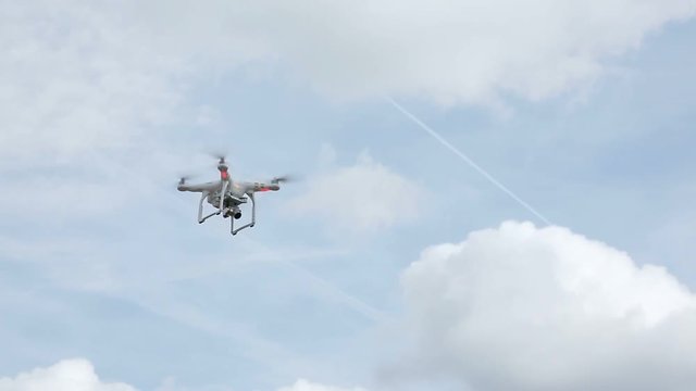 Quadcopter flying in the sky at sunny day