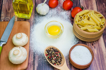 Still life with pasta ingredients and wooden accessories