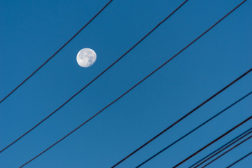 Day moon with electric cable.