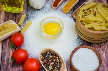 Still life with pasta ingredients and wooden accessories