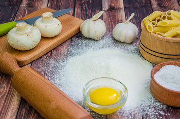 Still life with pasta ingredients and wooden accessories