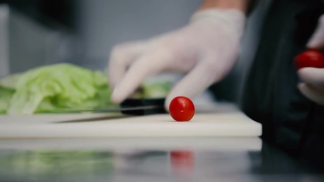 Man cuts consume cherry tomatoes.