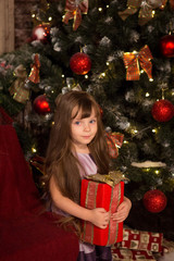 Little girl with christmass gift in her hands