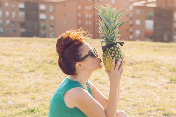 hipster woman kissing a funny pineapple with glasses