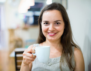 Beautiful brunette girl drinking tea in cafe