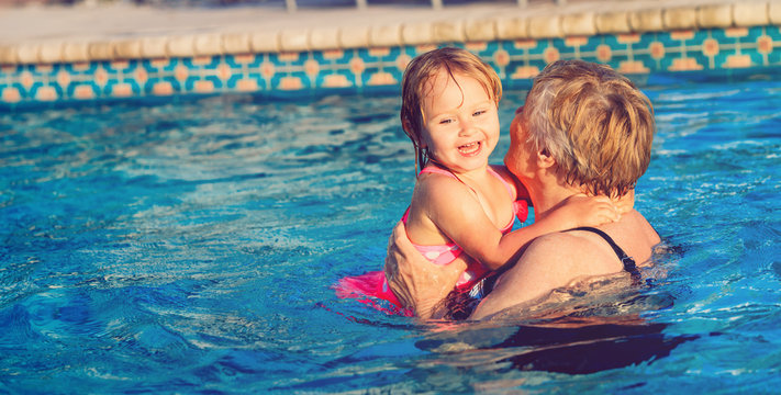 grandmother teaching little granddaughter to swim