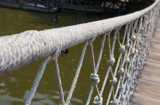 Rope bridge with wooden planks leading into distance