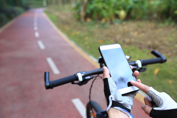 cyclist hands use gps navigator on smartphone while biking