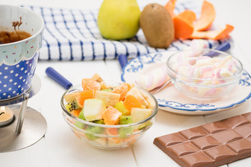 Fondue chocolate, marshmallows, apple, tangerine, kiwi and banana.
