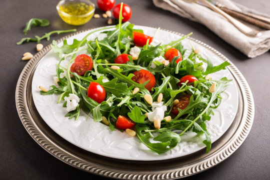 fresh vegetable salad with rucola, tomatos and goat cheese. Healthy food concept.