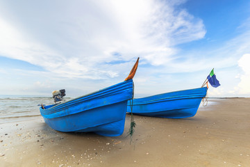 Blue fishing boats on the beach with nice sky