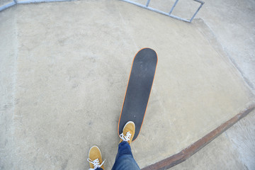 young skateboarder legs riding skateboard at skatepark ramp © lzf