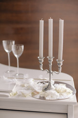 Composition with candlestick with candles and glasses