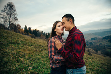 Beautiful loving couple in hipster fashion style posing on mountain