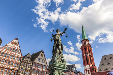 Naklejka premium lady Justice at roemerberg in Frankfurt with half timbered houses and Nicolai church