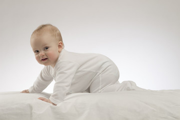 Crawling cute baby boy on the white background. Studio shot