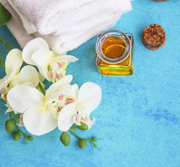 Fototapeta na wymiar Spa set with orchid, honey for skin treatments and cotton towels on painted wood