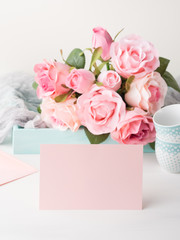 Blank pink paper card for Valentine's or mother woman day. Wedding baby birthday romantic date invitation. Background with roses tray romantic textile and two coffee cups