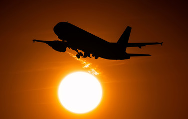 Airplane on takeoff flying across the solar disk, the engine leaves a trail of hot air