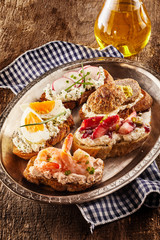 Naklejka premium Selection of canapes on a rustic dish