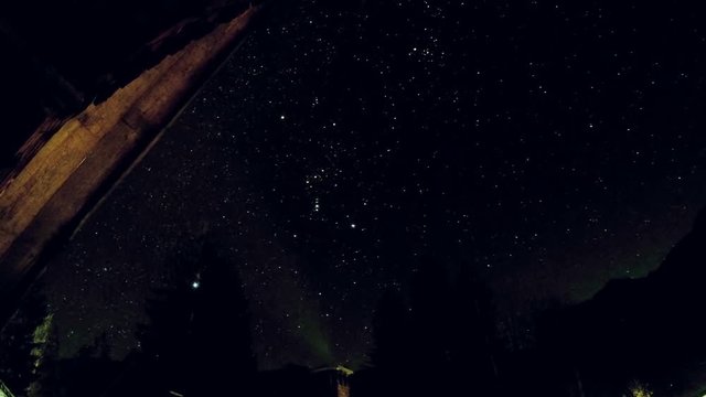 Night time lapse footage of bright stars moving across the dark winter sky