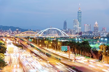 Fototapeta na wymiar Night scenery of Taipei City, with Taipei 101 Tower in XinYi District, downtown area with arch bridges and car trails on Dike Avenue ~ Romantic cityscape of Taipei at dusk by riverside (long exposure)